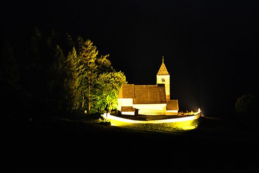 Aussicht auf die beleuchtete St Remigius Kirche in Falera